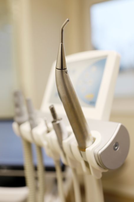 Zahnarztinstrumente in einem Behandlungsraum, schimmernd und steril.