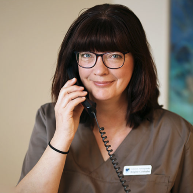Frau mit Brille spricht am Telefon.