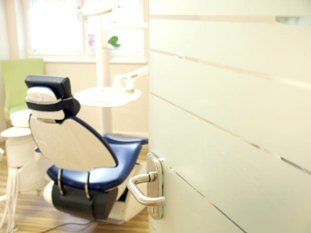 Zahnbehandlungsstuhl in einem modernen, hellen Behandlungsraum.