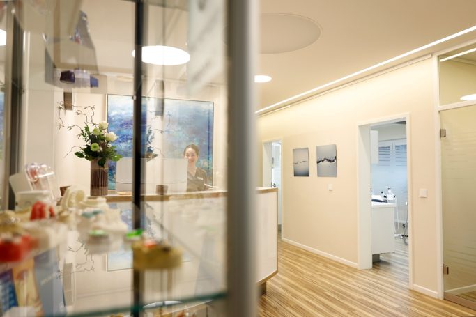 Heller, moderner Empfangsbereich mit Pflanzen und Bildern an den Wänden.